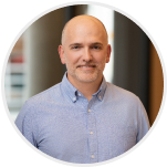 Headshot of Nick Gavronsky, Co-Founder & CEO, smiling in a white shirt.