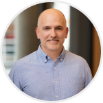 Headshot of Nick Gavronsky, Co-Founder & CEO, smiling in a white shirt.